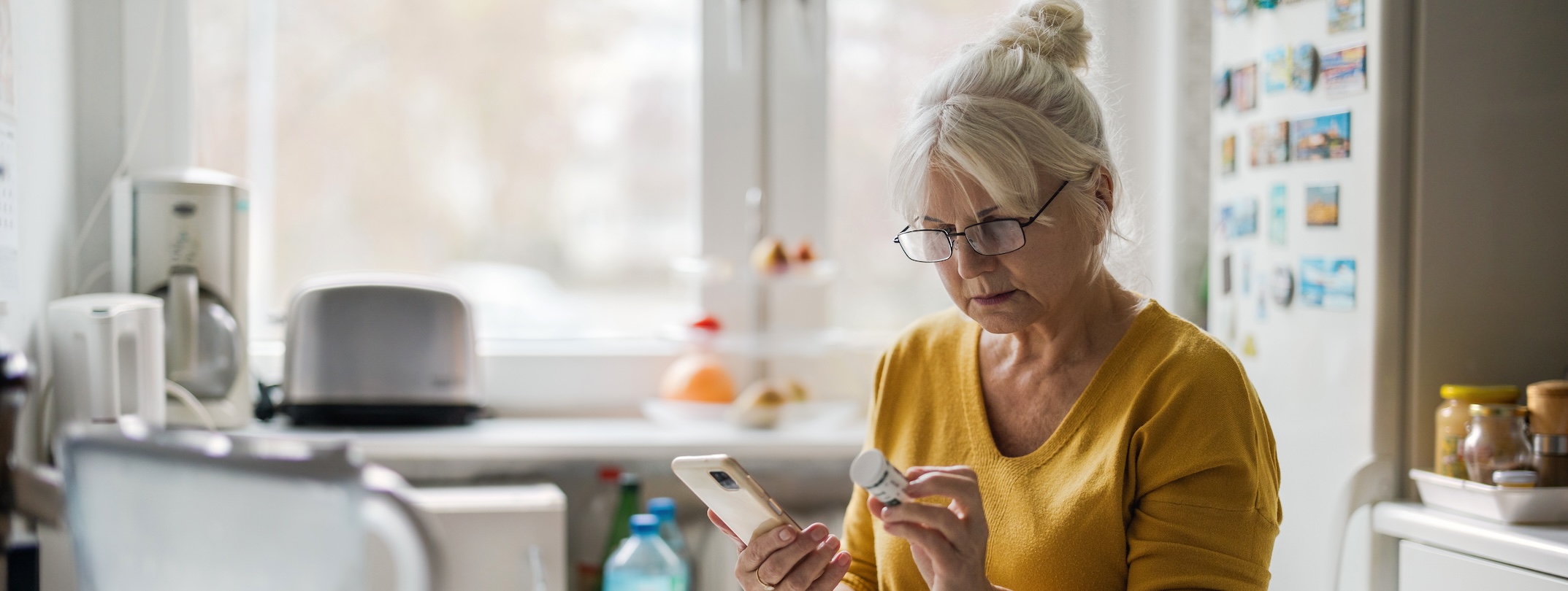 woman viewing pill bottle in a lit room